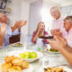 A group of people enjoying a party and sitting around a table.