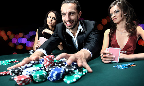 Man smiling as he rakes in chips